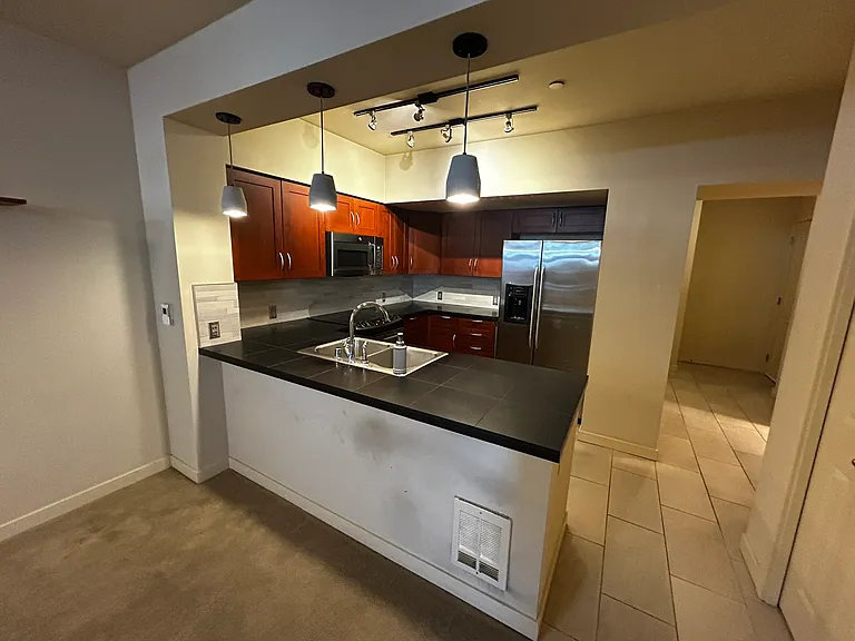 Hallway to the right of kitchen leads to back entrance towards Garage.
