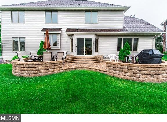 Newer stone patio just off the kitchen. Great seating space, grilling area and stairs out to the plush backyard.