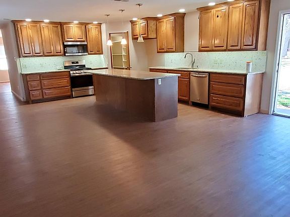 Custom Kitchen featuring custom wood cabinetry, granite countertops and stainless steel appliances
