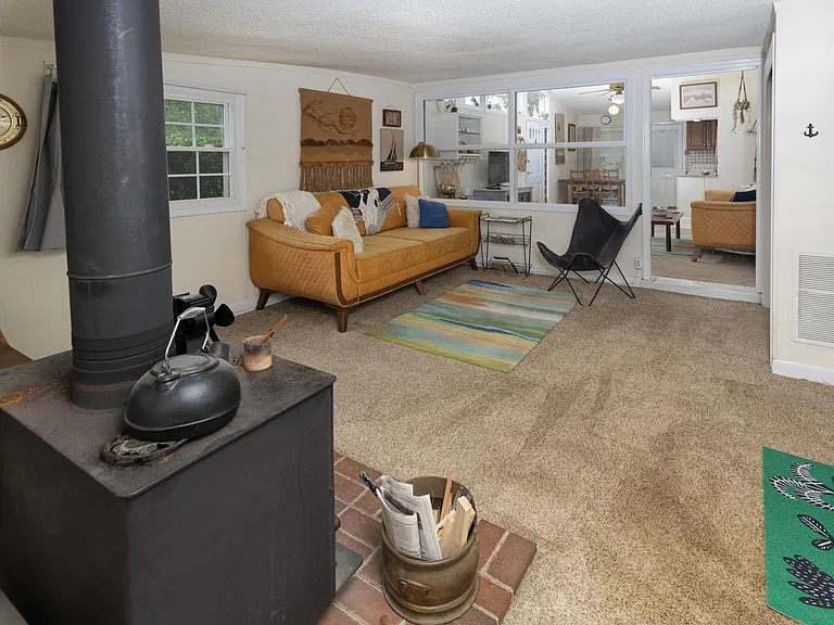 den off of the living room with a wood stove