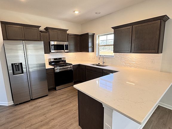kitchen equipped with all stainless-steel appliances included, quartz kitchen countertops with an o