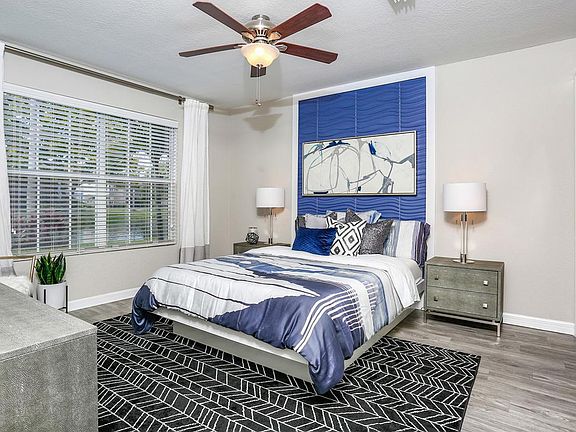 Master bedrooms featuring wood-style flooring, a walk-in closet, and a ceiling fan.