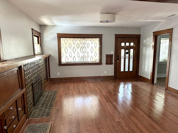 This huge sunlit living room features the original woodturning fire place in the preserved built in cabinet. Home comes with window coverings handmade with love for each window. Feel free to change these to your own style as you make this house your home.