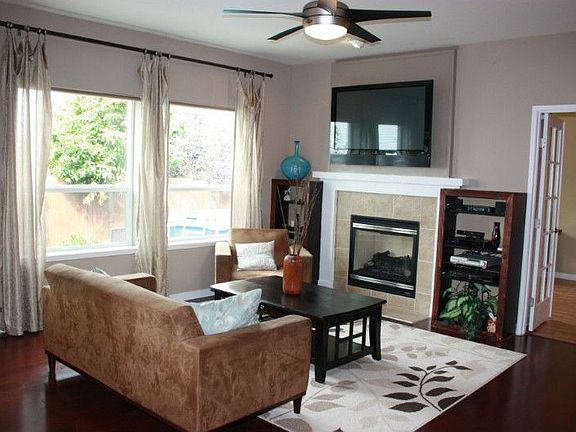 Spacious family room with beautiful hardwood floors, a gas fireplace and ceiling fan.