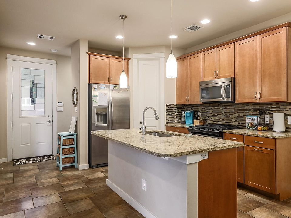 Open kitchen w/ granite countertops, stainless steel appliances & direct access to backyard porch and private yard.