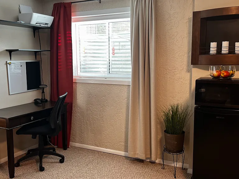 Large mini fridge with freezer & dedicated workspace for remote work or business travel.