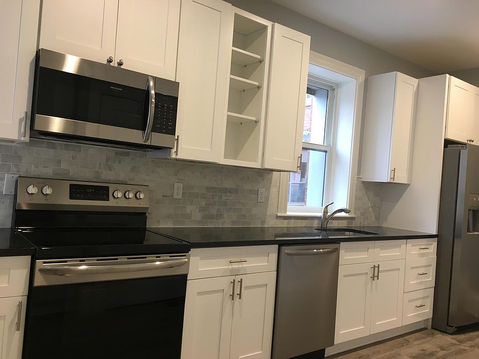 Kitchen with marble backsplash and 
 black granite countertops