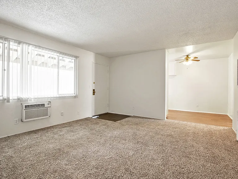 Living room with air conditioning, carpeted flooring , ceiling fan in dining area
