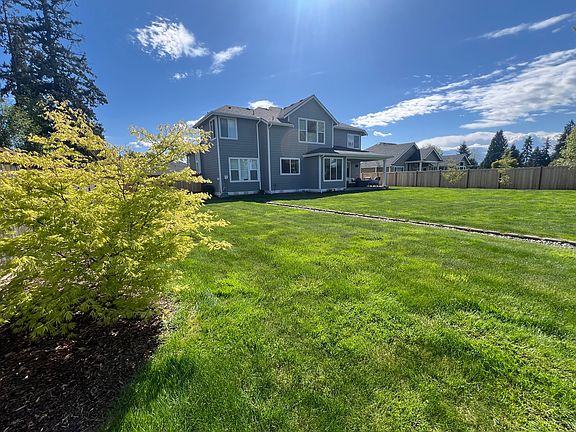 huge backyard with nice gardens and trees