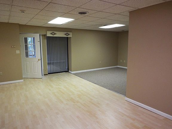 Open area with laminate flooring and carpeted living room; o