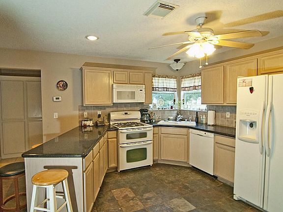 The kitchen is adjacent to the den and has a breakfast bar.