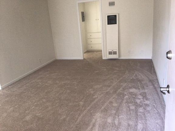 Entering front door to Living room, and hallway leading to bath on the right and bedroom on the left