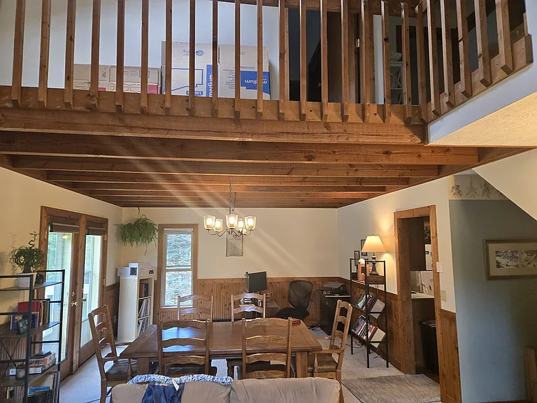 Dining room with beam ceilings, walkway on second floor