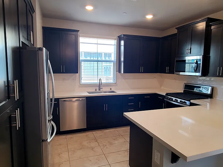 View of the kitchen from the dining room. The island can fit three barstools.