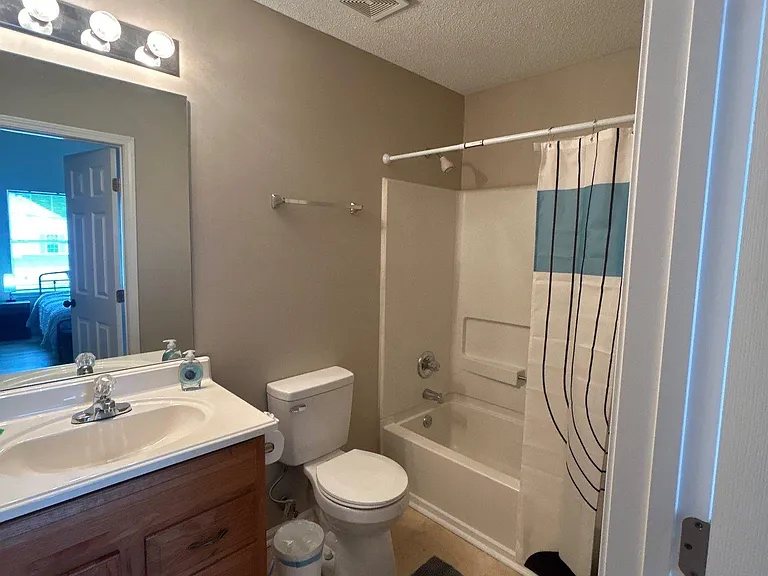 Full bath with single-sink vanity, large mirror, and tub/shower combo with curtain for easy daily use.