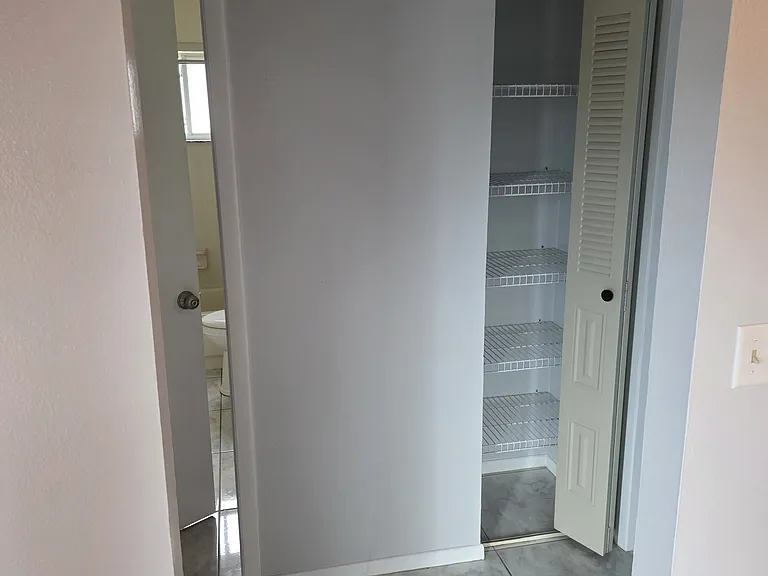 leading into hall way to bathroom with 2 bed rooms and closet in hallway