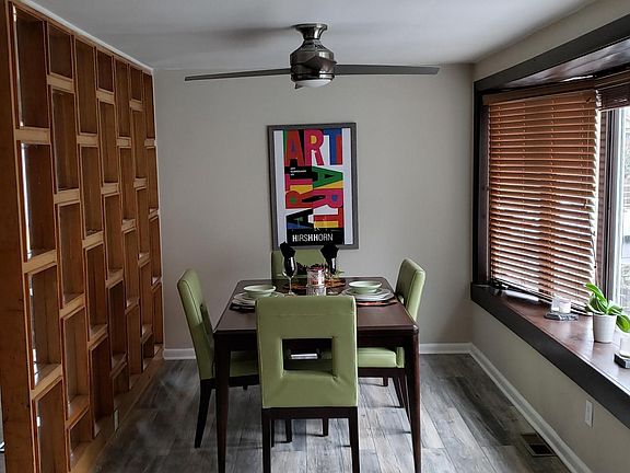 Dining room with bay windows and new hardwood floors...over looks back yard, trees and grass.