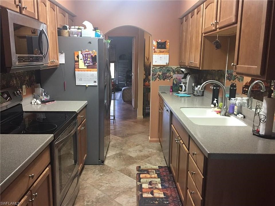 BEAUTIFUL KITCHEN WITH CORIAN COUNTER TOPS, STAINLESS STEEL APPLIANCES, NUMEROUS CABINETS, PORCELAIN TILE FLOOR ON THE DIAGONAL.