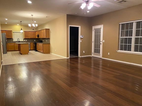 Great Room--very spacious! Picture was taken from the corner nearest the front door. Doors in the middle go into the primary suite and back patio.