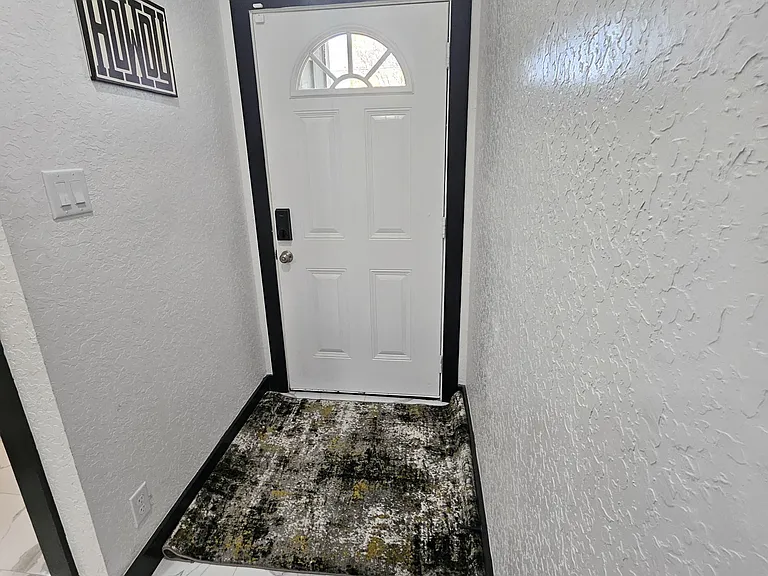 Secure interior entry area providing clear access to private rooms and common space.