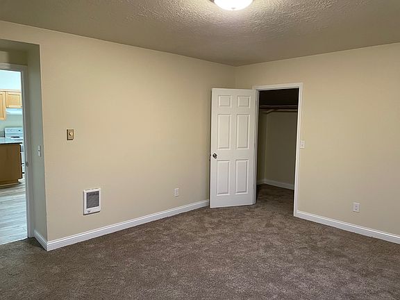 Bedroom and closet with view into kitchen