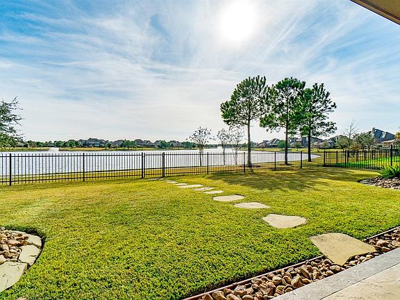 And, here's the marvelous view from the back patio which is stained, patterned concrete. The view is enhanced with crisp landscaping and back wrought-iron fence.