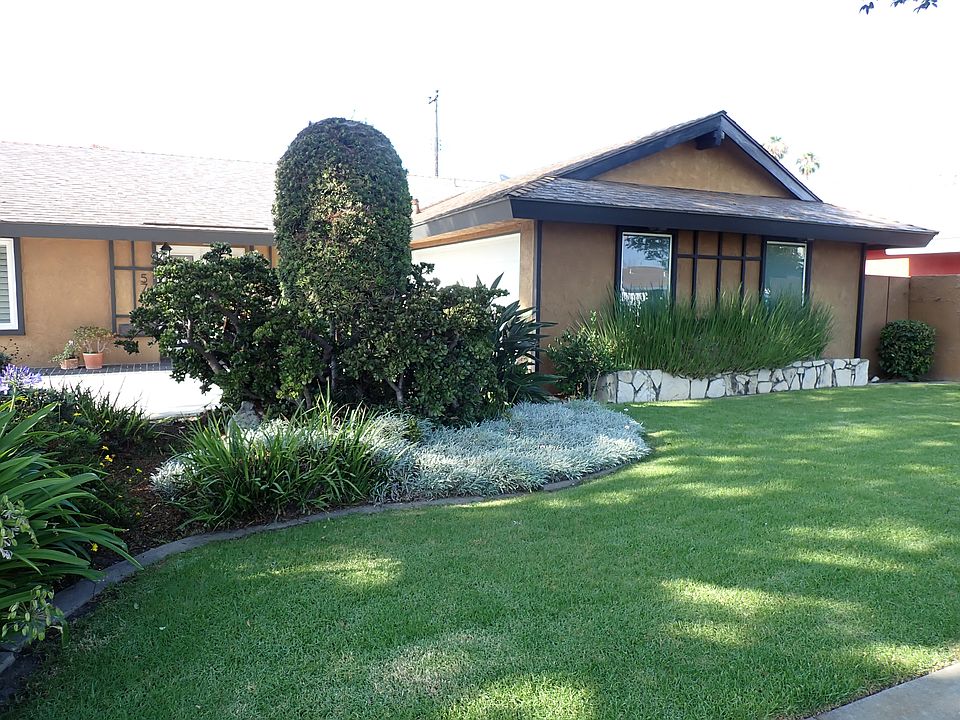 Front of home with curb appeal and lush front yard
