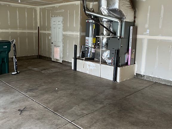 Three car garage with exiting dog door to small fenced area. One single garage door and a double.