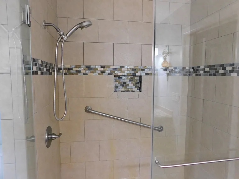 Some beautiful tile work in the shower, complete with detachable faucet and hand rails for safety!