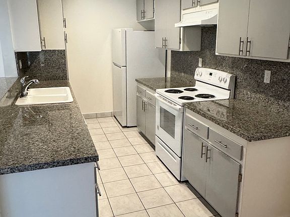 Kitchen with electric stove, dishwasher, refrigerator and garbage disposal.