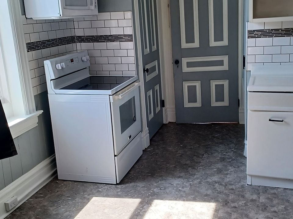 Big eat in kitchen with washer/dryer hookups. Microwave, electric stove, attractive backsplash. Original doors.