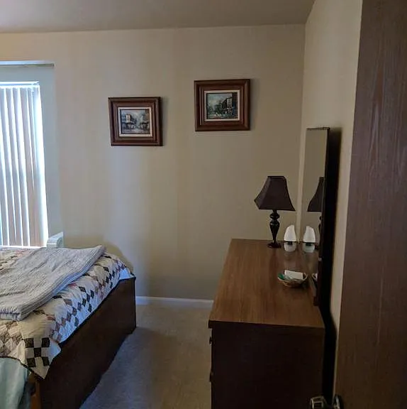 Bedroom #1 entrance (on the parking lot side of the unit), foot of the bed showing, along with dresser.
