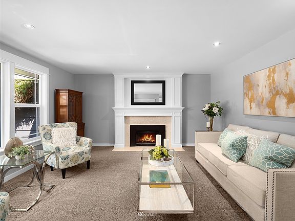 Spacious living room with wood-wrapped natural gas fireplace.