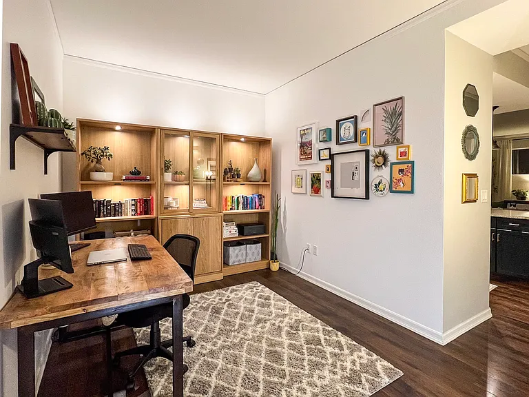 Beautiful built in shelving in large office/ den. Desk and monitor setup perfect for a working professional.