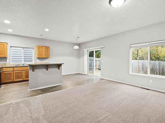 Open spacious living, dining and kitchen looking out at the backyard. 

Not shown: New luxury vinyl flooring, new dining light fixture, new living room ceiling fan