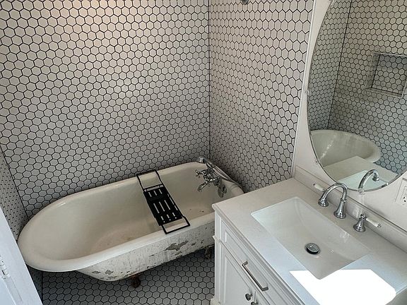 Antique clawfoot cast iron bathtub and shower.