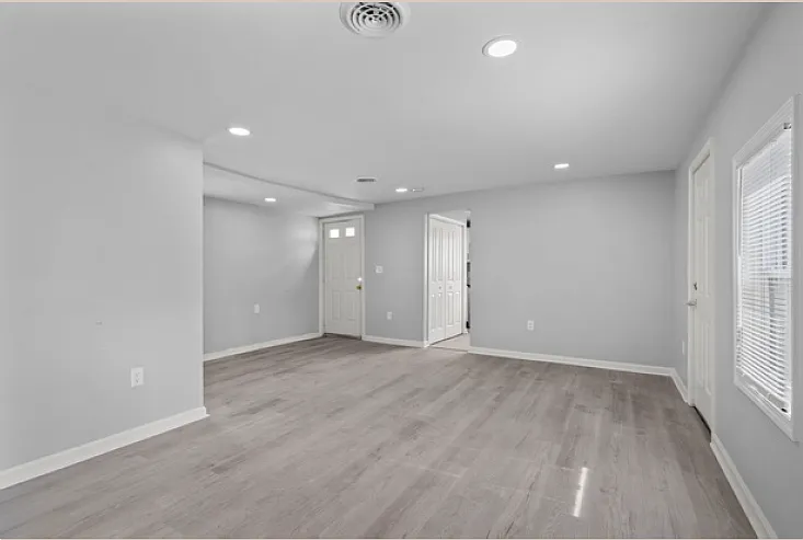 View of the living space, with entry door and kitchen doorway.
