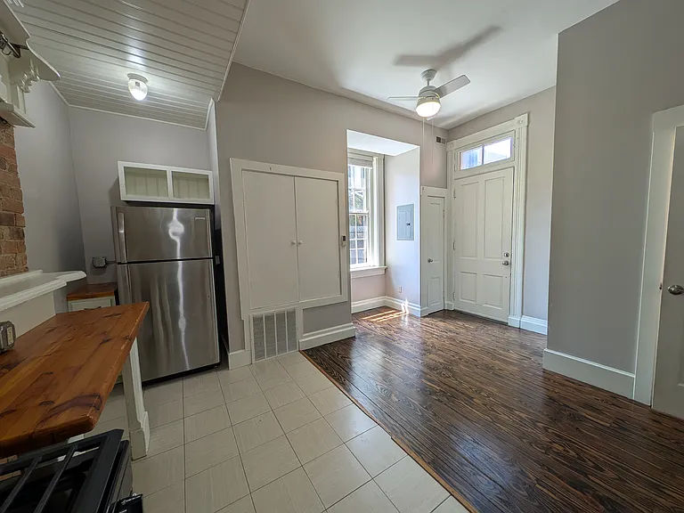 Another angle of the kitchen, which includes a half-bath and exterior door to private back patio.