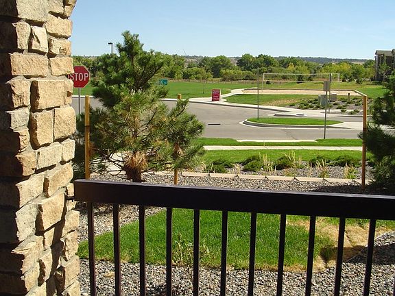 View of the volleyball ball court and playground from one of two patios. This patio has a large storage unit attached.