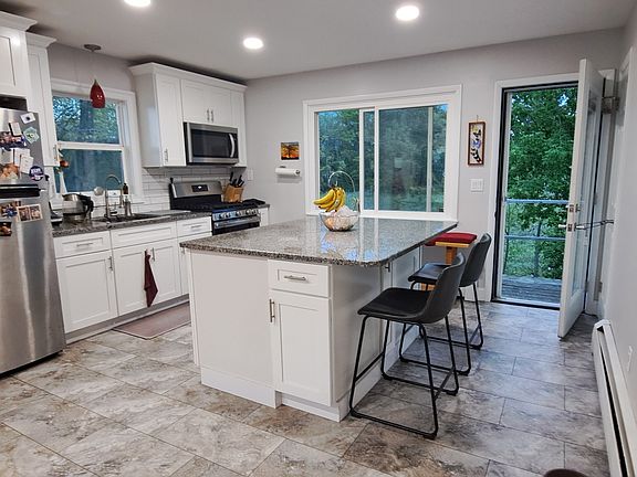 Kitchen-vinyl flooring, granite island with 2 chairs, deck overlooking back yard.