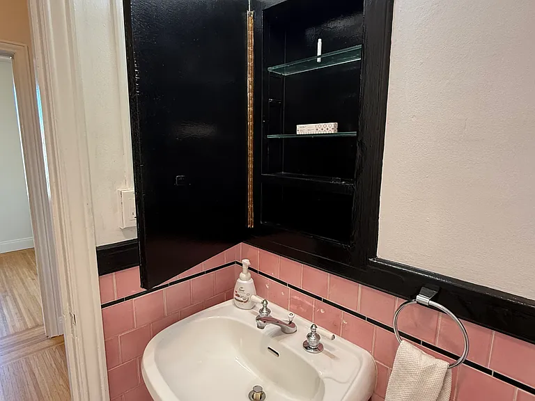 Pedastal sink with makeup-ready lighting and medicine cabinet for your things.