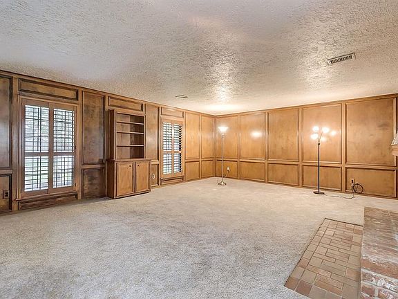The huge Living Room features stately natural-stained block paneling with lots of natural light and built-ins.