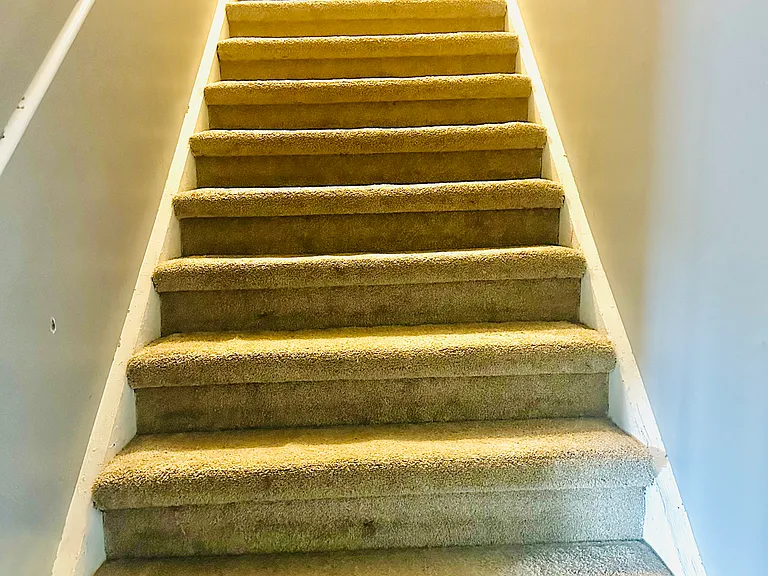 Stairs leading upstairs to another larger bedroom and an office or room-without a closet, mini splits upstairs for added comfort.