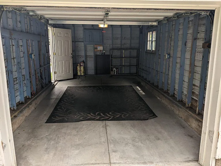 View of the garage from the overhead door with side entrance on the far left.
