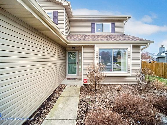 Walking up to front door with professionally landscaped yard