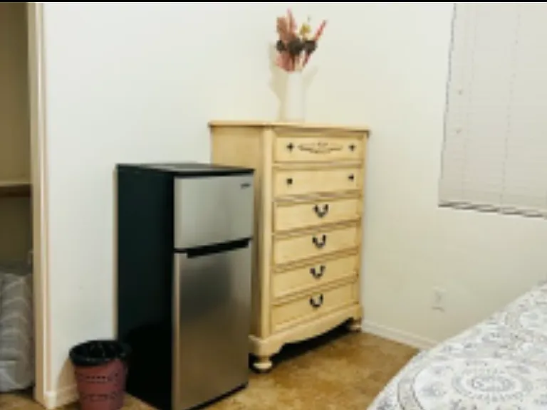 Dresser, in room fridge/freezer, laundry bin, double decker closet, full-sized bed with under the bed storage for totes.