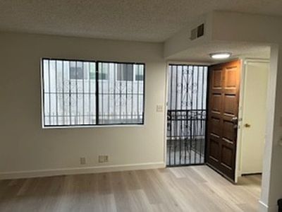 Front door leading to large living room with fireplace and new hardwood floors.