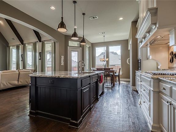 Natural light cascades throughout the living room and kitchen.
