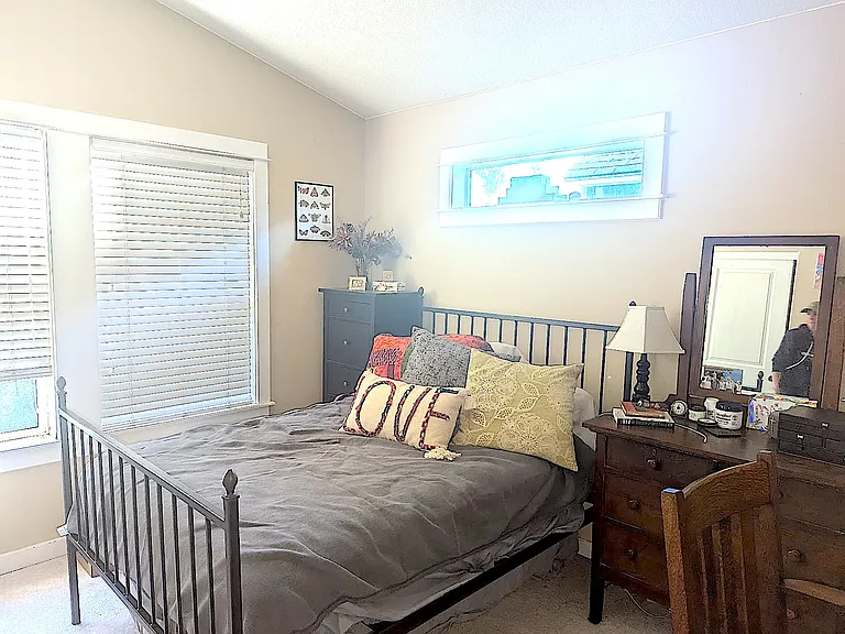 Large primary bedroom with vaulted ceilings, tree canopy views, two separate closets, and en-suite full bath.