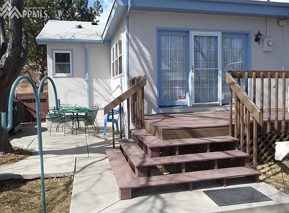 Composite Deck at rear of home that steps down to concrete patio area with patio table and chairs (included). Trees for shade an
